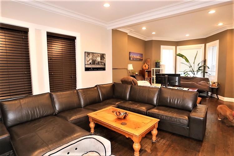A living room with a black leather couch and a wooden coffee table.