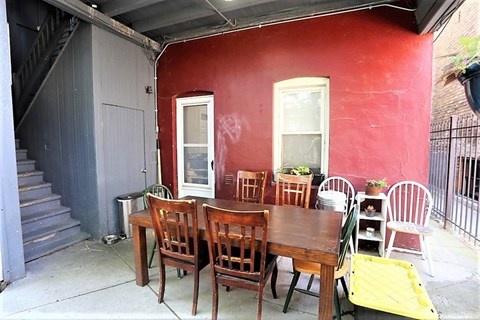A red building with a table and chairs outside.