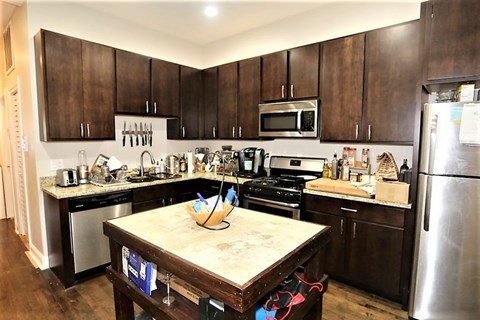 A kitchen with dark wood cabinets and stainless steel appliances.