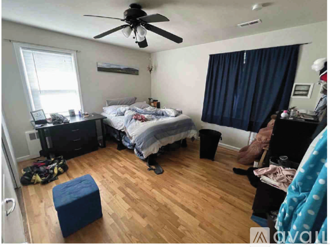 A bedroom with a bed, dresser, and window.
