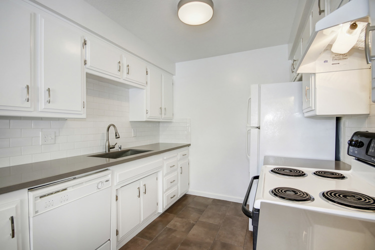 A white kitchen with a stove top oven.