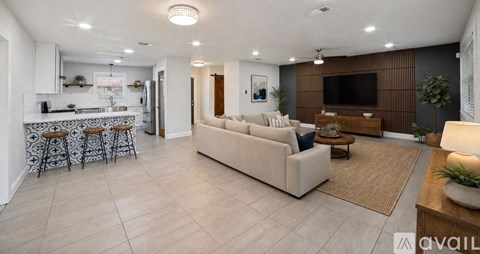 A spacious living room with a beige sofa and a television.
