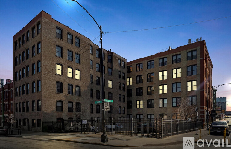 Two buildings with windows are lit up by the sunset.