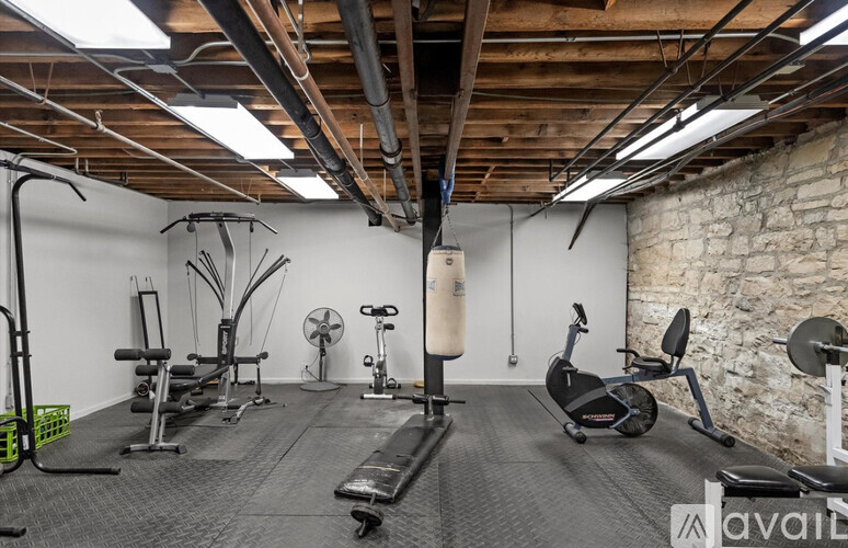 A gym with a variety of equipment including a treadmill, weights, and a fan.