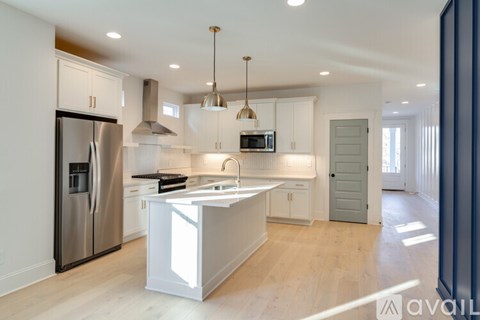 A modern kitchen with a stainless steel refrigerator and a central island.