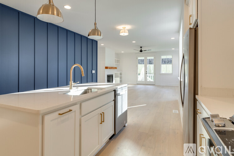 A modern kitchen with a white countertop and blue wall paneling.