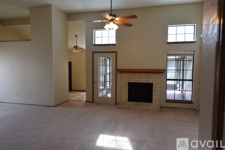 A living room with a fireplace and a ceiling fan.
