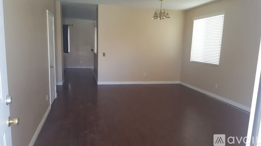 A room with wooden floors and a chandelier.
