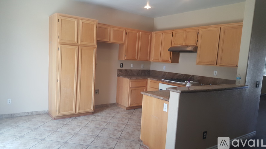 A kitchen with wooden cabinets and a refrigerator.
