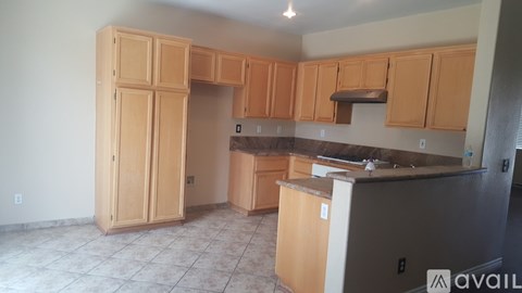 A kitchen with wooden cabinets and a refrigerator.