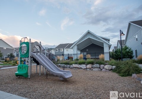 A playground with a green slide and a play structure.