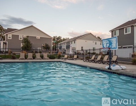 A pool with chairs and a sign that says "available" in front of a residential area.