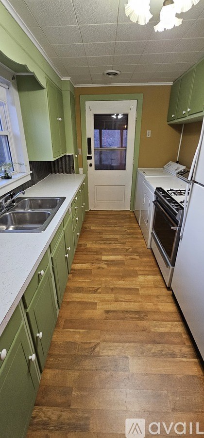 A kitchen with green cabinets and a white countertop.