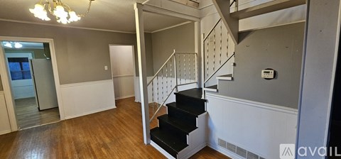 A spacious room with a staircase leading to the upper floor.