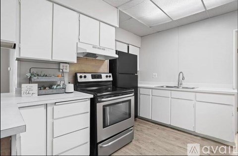 A kitchen with white cabinets and a black stove top oven.