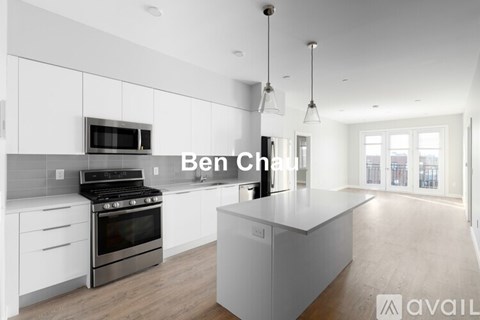 A modern kitchen with white cabinets and a large island.