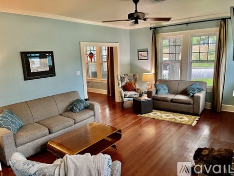 A living room with a grey couch and a wooden coffee table.