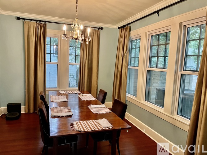 A dining room with a wooden table set for a meal.