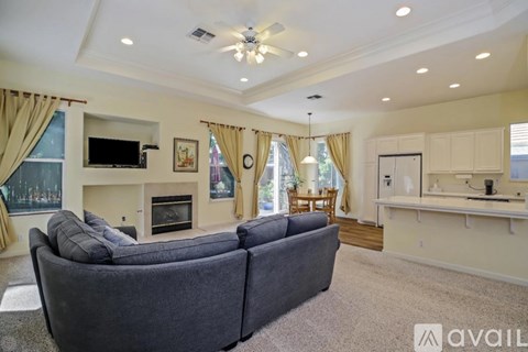 A living room with a grey couch and a fireplace.