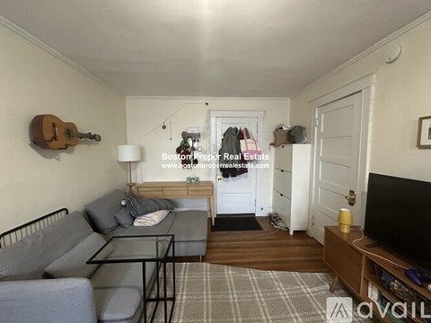 A living room with a grey couch and a wooden coffee table.