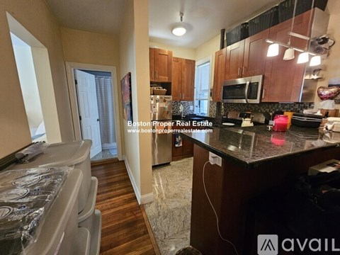 A kitchen with a black countertop and wooden cabinets.