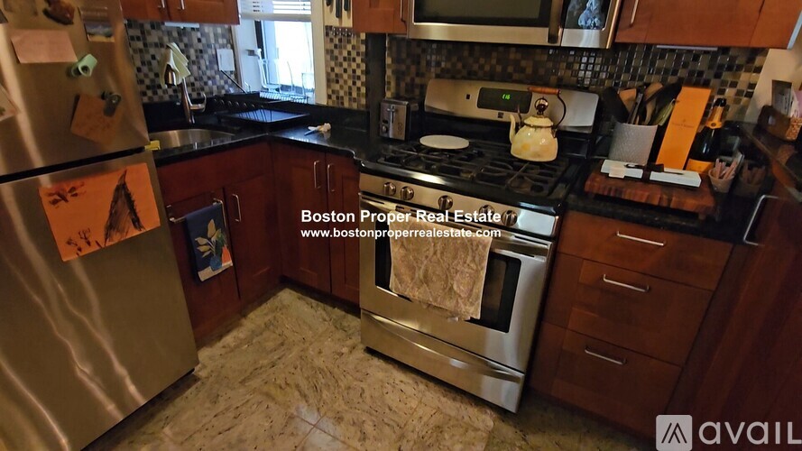 A kitchen with a stove top oven and a refrigerator.