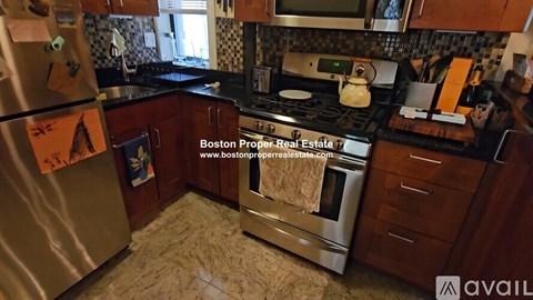 A kitchen with a stove top oven and a refrigerator.