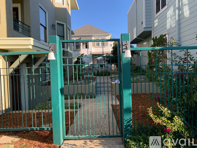 A green metal gate blocks the entrance to a driveway.