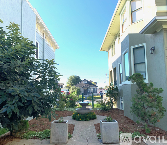 A sunny day in a residential area with houses and a fountain.