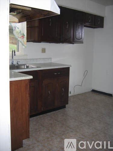 A kitchen with wooden cabinets and a white counter top.