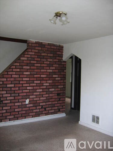 A room with a red brick wall and a white ceiling.