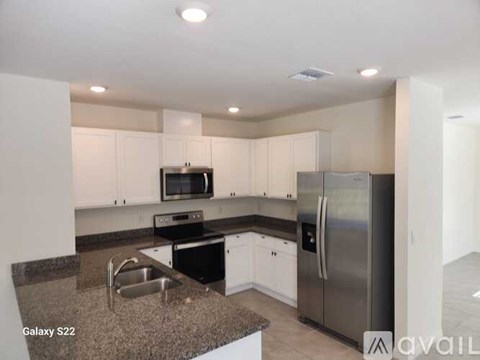 A kitchen with granite countertops and stainless steel appliances.