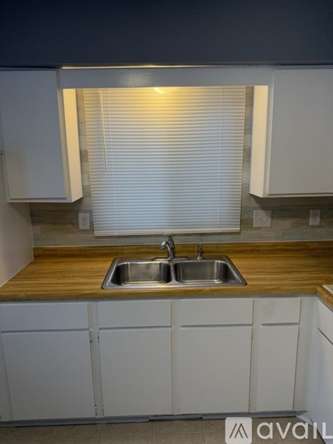 A kitchen with a sink and wooden countertop.
