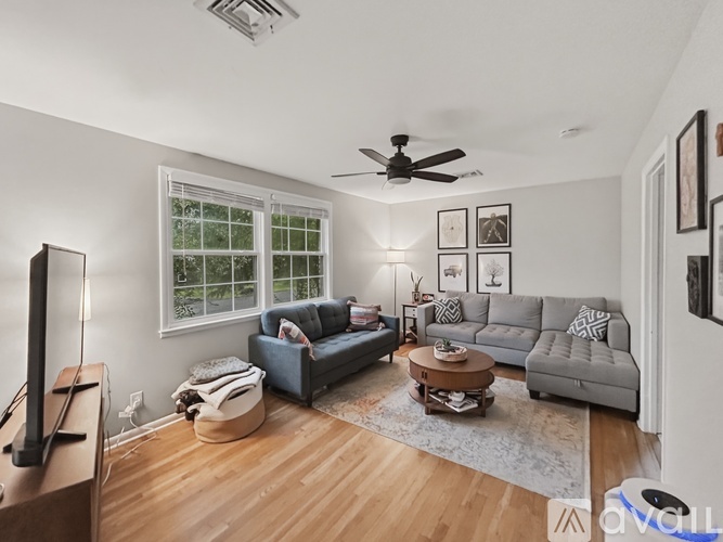 A living room with a grey couch, a brown coffee table, and a flat screen TV.