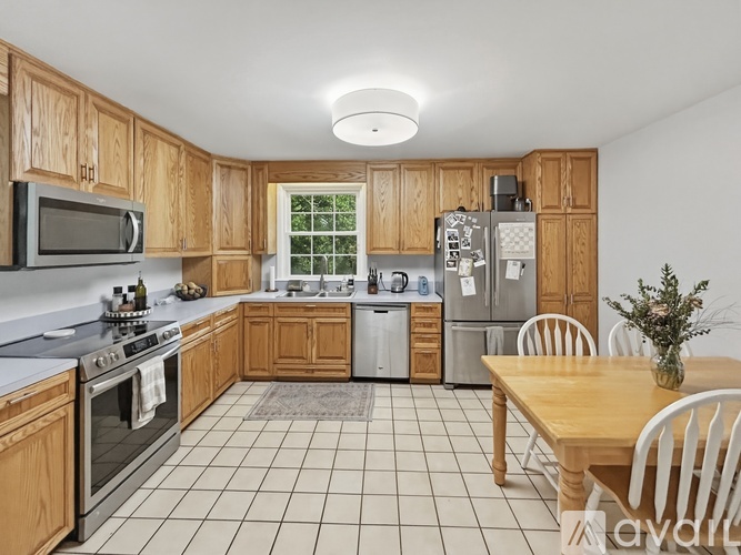 A kitchen with wooden cabinets and a tile floor.