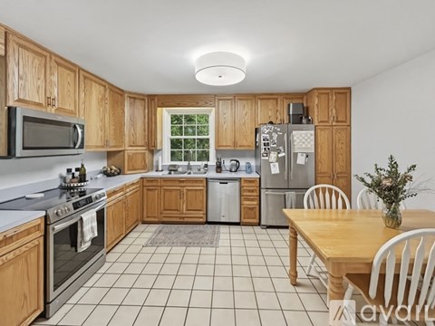 A kitchen with wooden cabinets and a tile floor.