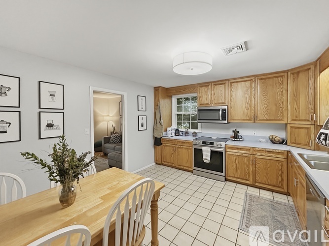 A kitchen with wooden cabinets and a dining table with chairs.
