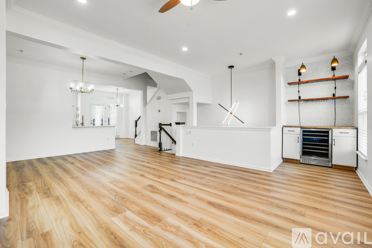 A spacious room with wooden floors and a ceiling fan.