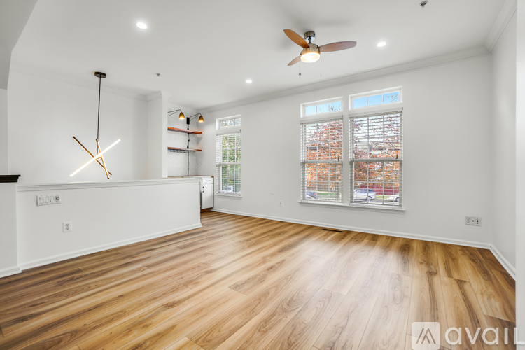 A spacious room with wooden flooring and a ceiling fan.