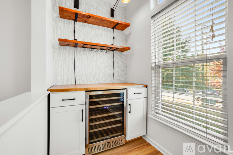 A kitchen with a white cabinet and a white oven with a wooden shelf above it.
