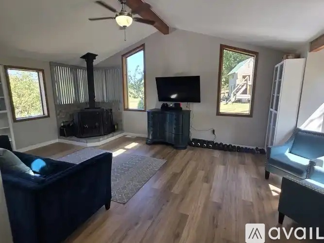 A living room with a dark blue couch and a wood burning stove.