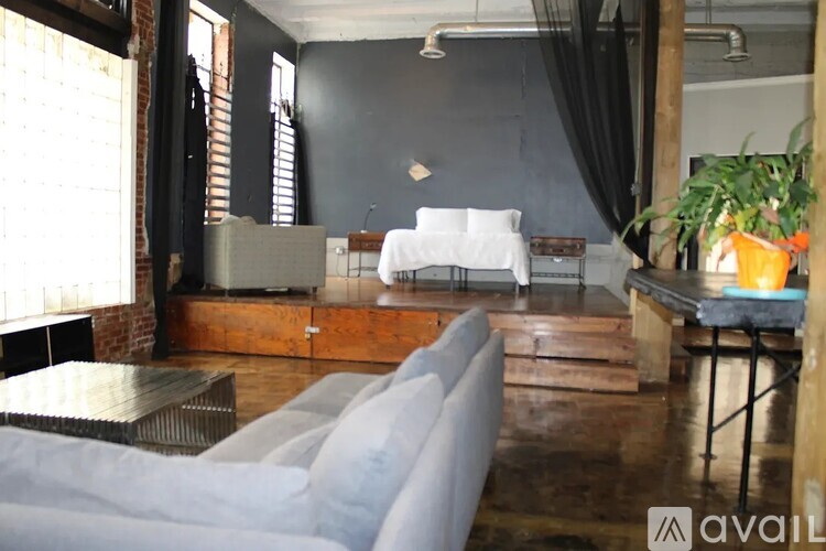 A living room with a grey couch and a wooden coffee table.