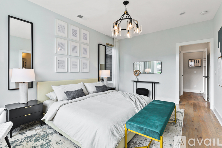 A bedroom with a large bed and a green bench.