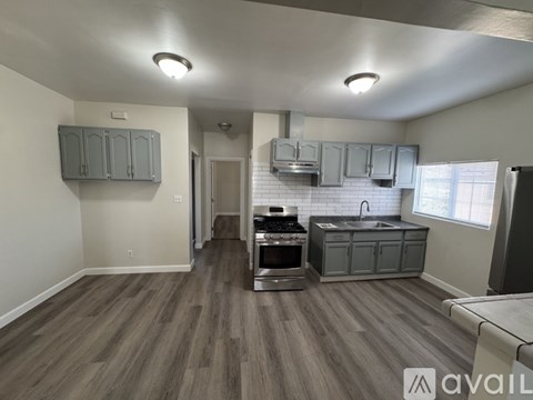 A kitchen with a stove top oven and a sink.
