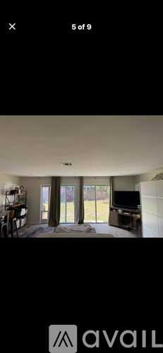 A room with a sliding glass door leading to a backyard.