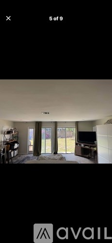 A room with a sliding glass door leading to a backyard.