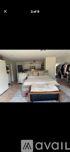 A bedroom with a bed, a couch, and a TV.