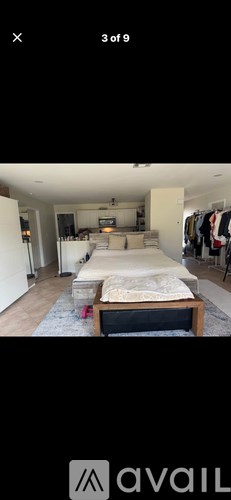 A bedroom with a bed, a couch, and a TV.