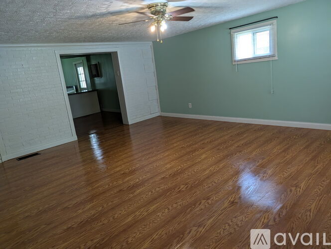 A room with wooden flooring and a ceiling fan.