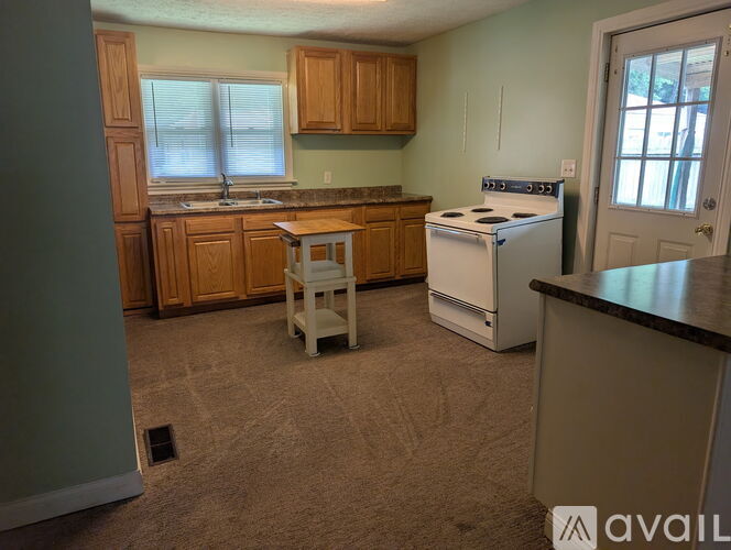 A kitchen with a white stove and wooden cabinets.